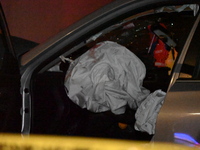 Crime scene investigators collect evidence, mark evidence with evidence markers, and inspect the vehicle airbag with blood on it from the vi...