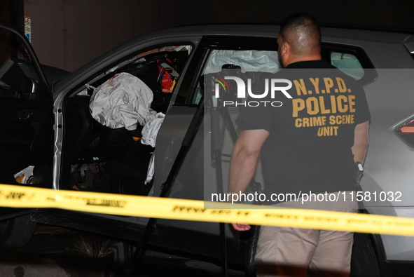 Crime scene investigators collect evidence, mark evidence with evidence markers, and inspect the vehicle airbag with blood on it from the vi...