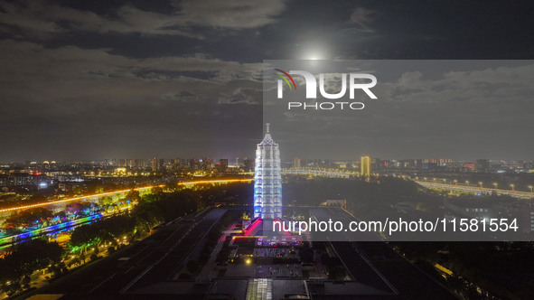 A supermoon appears over the Porcelain Tower of Nanjing in Nanjing, China, on September 17, 2024. 