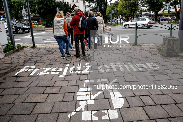 Walk offline sign is seen on a pavement on a landmark Krupowki Street in the center of Zakopane, a popular Tatra mountain holiday resort as...