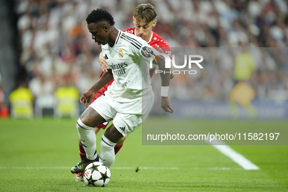 Vinicius Junior left winger of Real Madrid and Brazil and  Anthony Rouault centre-back of Stuttgart and France compete for the ball during t...