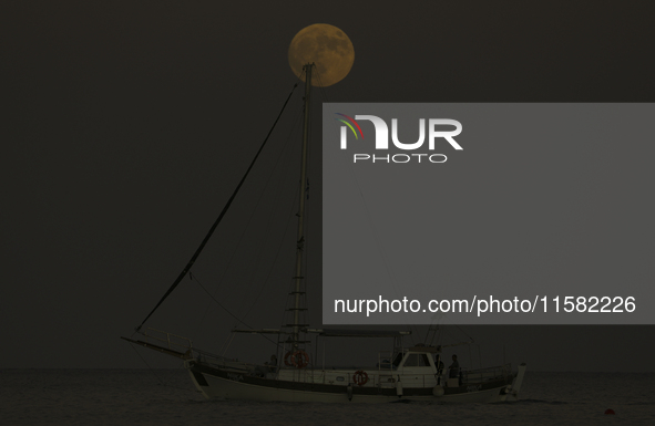 The supermoon rises over a yacht as it passes off the coast of the southern Mediterranean port of Larnaca. Cyprus, Tuesday, September 17, 20...