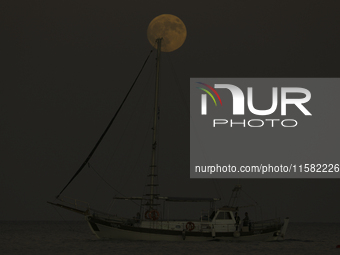 The supermoon rises over a yacht as it passes off the coast of the southern Mediterranean port of Larnaca. Cyprus, Tuesday, September 17, 20...