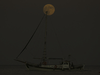 The supermoon rises over a yacht as it passes off the coast of the southern Mediterranean port of Larnaca. Cyprus, Tuesday, September 17, 20...