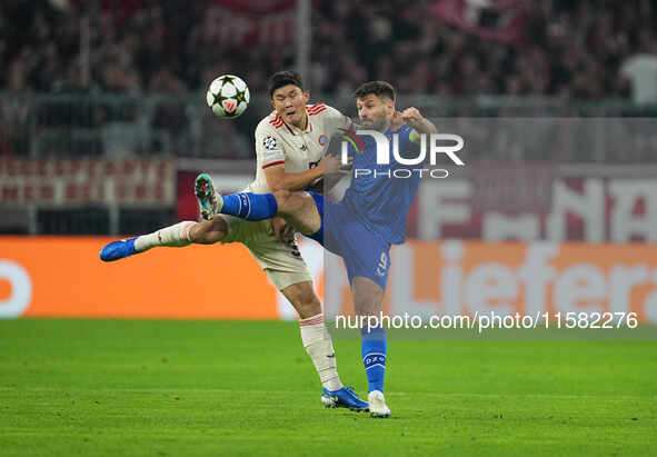 Minjae Kim of Bayern Munich and Bruno Petković of GNK Dinamo battle for the ball  during the Champions League Round 1 match between Bayern M...