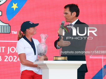 GAINESVILLE, VIRGINIA - SEPTEMBER 15: Sports commentator Grant Boone speaks with Captain Stacy Lewis of the United States as she holds the t...