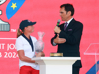 GAINESVILLE, VIRGINIA - SEPTEMBER 15: Sports commentator Grant Boone speaks with Captain Stacy Lewis of the United States as she holds the t...