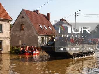 Residents are being evacuated by emergency workers on a military amphibious vehicle after Nysa Klodzka river flooded town of Lewin Brzeski i...