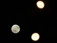 Small lights in a tree by a restaurant are seen with the Harvest Moon in the night sky over Frankfurt an der Oder, Germany on 17 September,...