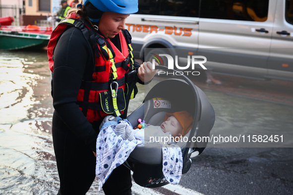 A baby is being evacuated by an emergency worker after Nysa Klodzka river flooded town of Lewin Brzeski in southwestern Poland, on September...