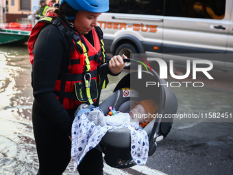 A baby is being evacuated by an emergency worker after Nysa Klodzka river flooded town of Lewin Brzeski in southwestern Poland, on September...