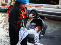 A baby is being evacuated by an emergency worker after Nysa Klodzka river flooded town of Lewin Brzeski in southwestern Poland, on September...