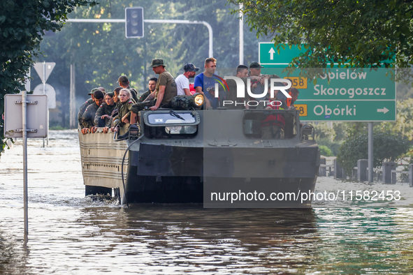 Residents are being evacuated on a military amphibious vehicle by emergency workers after Nysa Klodzka river flooded town of Lewin Brzeski i...