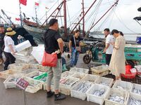 Citizens buy various kinds of seafood unloaded at Jimiya fishing Port in the West Coast New Area in Qingdao, China, on September 18, 2024. (