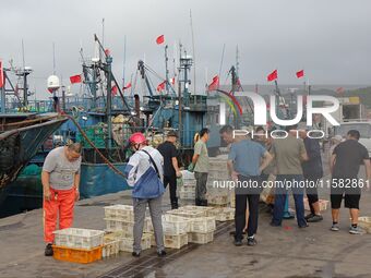 Citizens buy various kinds of seafood unloaded at Jimiya fishing Port in the West Coast New Area in Qingdao, China, on September 18, 2024. (