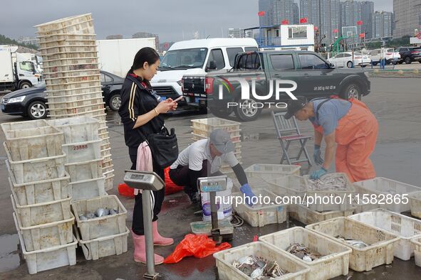 Citizens buy various kinds of seafood unloaded at Jimiya fishing Port in the West Coast New Area in Qingdao, China, on September 18, 2024. 