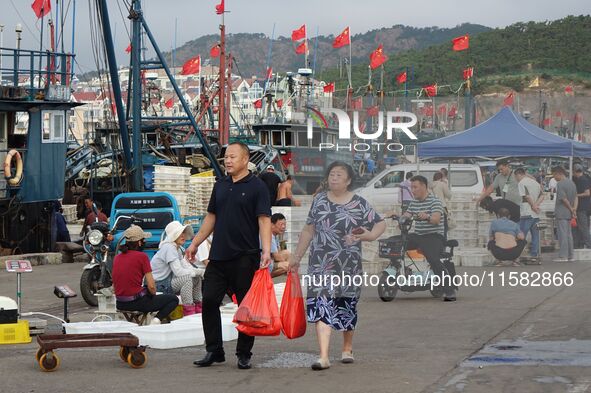 Citizens buy various kinds of seafood unloaded at Jimiya fishing Port in the West Coast New Area in Qingdao, China, on September 18, 2024. 