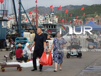 Citizens buy various kinds of seafood unloaded at Jimiya fishing Port in the West Coast New Area in Qingdao, China, on September 18, 2024. (