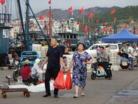 Citizens buy various kinds of seafood unloaded at Jimiya fishing Port in the West Coast New Area in Qingdao, China, on September 18, 2024. (