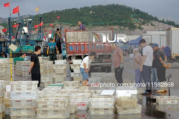 Citizens buy various kinds of seafood unloaded at Jimiya fishing Port in the West Coast New Area in Qingdao, China, on September 18, 2024. 