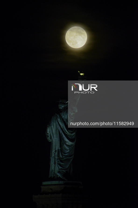 A partial lunar eclipse and supermoon occur in New York, United States, on September 17, 2024, as captured from Liberty Park in New Jersey....