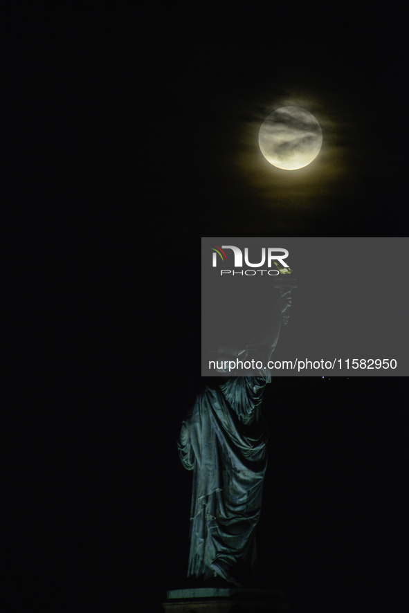 A partial lunar eclipse and supermoon occur in New York, United States, on September 17, 2024, as captured from Liberty Park in New Jersey....