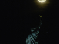 A partial lunar eclipse and supermoon occur in New York, United States, on September 17, 2024, as captured from Liberty Park in New Jersey....