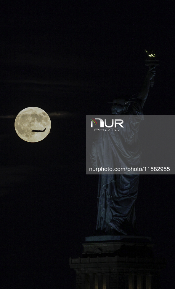 A partial lunar eclipse and supermoon occur in New York, United States, on September 17, 2024, as captured from Liberty Park in New Jersey....