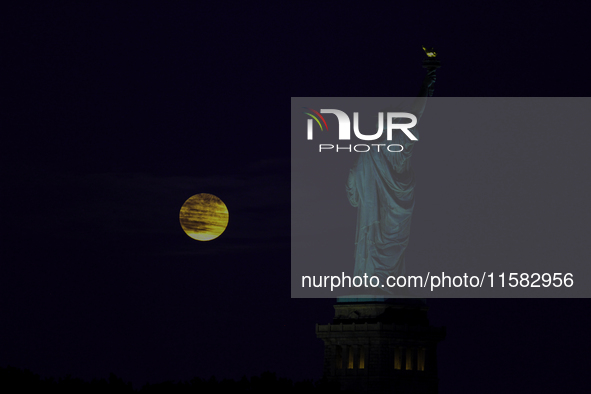 A partial lunar eclipse and supermoon occur in New York, United States, on September 17, 2024, as captured from Liberty Park in New Jersey....