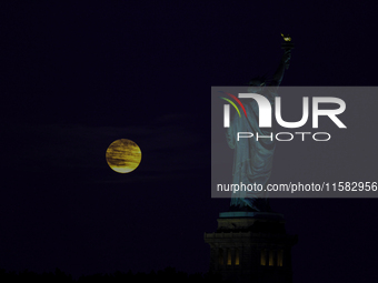 A partial lunar eclipse and supermoon occur in New York, United States, on September 17, 2024, as captured from Liberty Park in New Jersey....