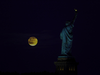 A partial lunar eclipse and supermoon occur in New York, United States, on September 17, 2024, as captured from Liberty Park in New Jersey....