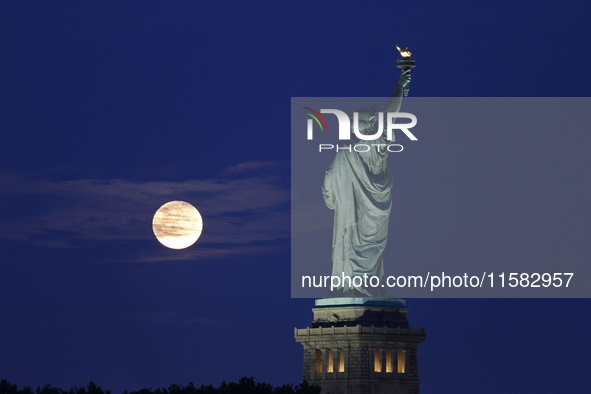 A partial lunar eclipse and supermoon occur in New York, United States, on September 17, 2024, as captured from Liberty Park in New Jersey....