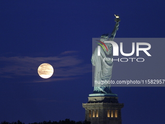 A partial lunar eclipse and supermoon occur in New York, United States, on September 17, 2024, as captured from Liberty Park in New Jersey....