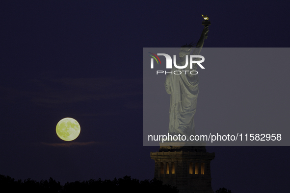 A partial lunar eclipse and supermoon occur in New York, United States, on September 17, 2024, as captured from Liberty Park in New Jersey....