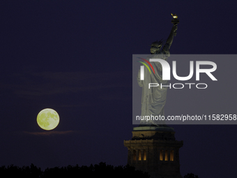 A partial lunar eclipse and supermoon occur in New York, United States, on September 17, 2024, as captured from Liberty Park in New Jersey....