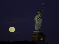 A partial lunar eclipse and supermoon occur in New York, United States, on September 17, 2024, as captured from Liberty Park in New Jersey....