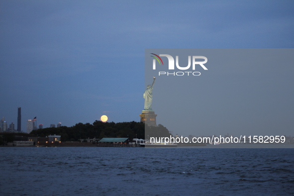 A partial lunar eclipse and supermoon occur in New York, United States, on September 17, 2024, as captured from Liberty Park in New Jersey....