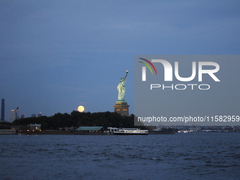 A partial lunar eclipse and supermoon occur in New York, United States, on September 17, 2024, as captured from Liberty Park in New Jersey....