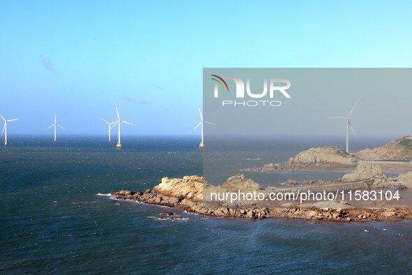 Wind turbines stand in the sea and rotate continuously at Pingtan Comprehensive Experimental Zone in Fujian, China, on September 17, 2024. 