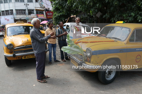 Taxi drivers perform puja on a Yakow Ambassador Taxi on Vishwakarma Puja in Kolkata, India, on September 17, 2024. The maker of India's Amba...