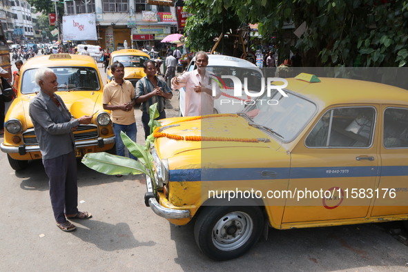 Taxi drivers perform puja on a Yakow Ambassador Taxi on Vishwakarma Puja in Kolkata, India, on September 17, 2024. The maker of India's Amba...