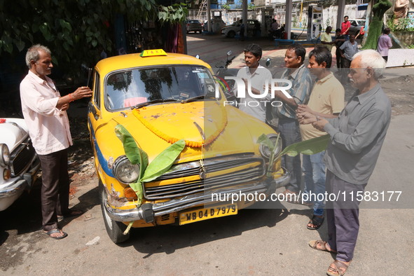 Taxi drivers perform puja on a Yakow Ambassador Taxi on Vishwakarma Puja in Kolkata, India, on September 17, 2024. The maker of India's Amba...