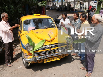 Taxi drivers perform puja on a Yakow Ambassador Taxi on Vishwakarma Puja in Kolkata, India, on September 17, 2024. The maker of India's Amba...