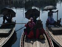 Boatmen hold umbrellas under the hot sun as they wait for passengers at the old Buriganga River channel in Dhaka, Bangladesh, on September 1...