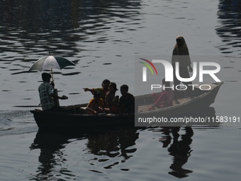 Children ride in a boat as it moves through the pitch-black water of the old Buriganga River channel in Dhaka, Bangladesh, on September 17,...