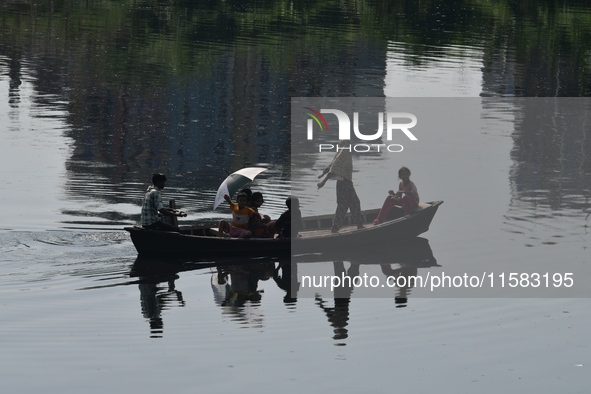 Children ride in a boat as it moves through the pitch-black water of the old Buriganga River channel in Dhaka, Bangladesh, on September 17,...