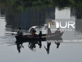 Children ride in a boat as it moves through the pitch-black water of the old Buriganga River channel in Dhaka, Bangladesh, on September 17,...