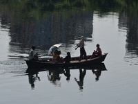 Children ride in a boat as it moves through the pitch-black water of the old Buriganga River channel in Dhaka, Bangladesh, on September 17,...