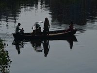 Children ride in a boat as it moves through the pitch-black water of the old Buriganga River channel in Dhaka, Bangladesh, on September 17,...