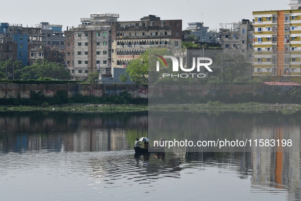 Children ride in a boat as it moves through the pitch-black water of the old Buriganga River channel in Dhaka, Bangladesh, on September 17,...